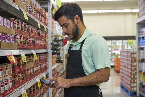 A retail worker using a scanner using a scanner that is managed and secured by the SOTI ONE Platform